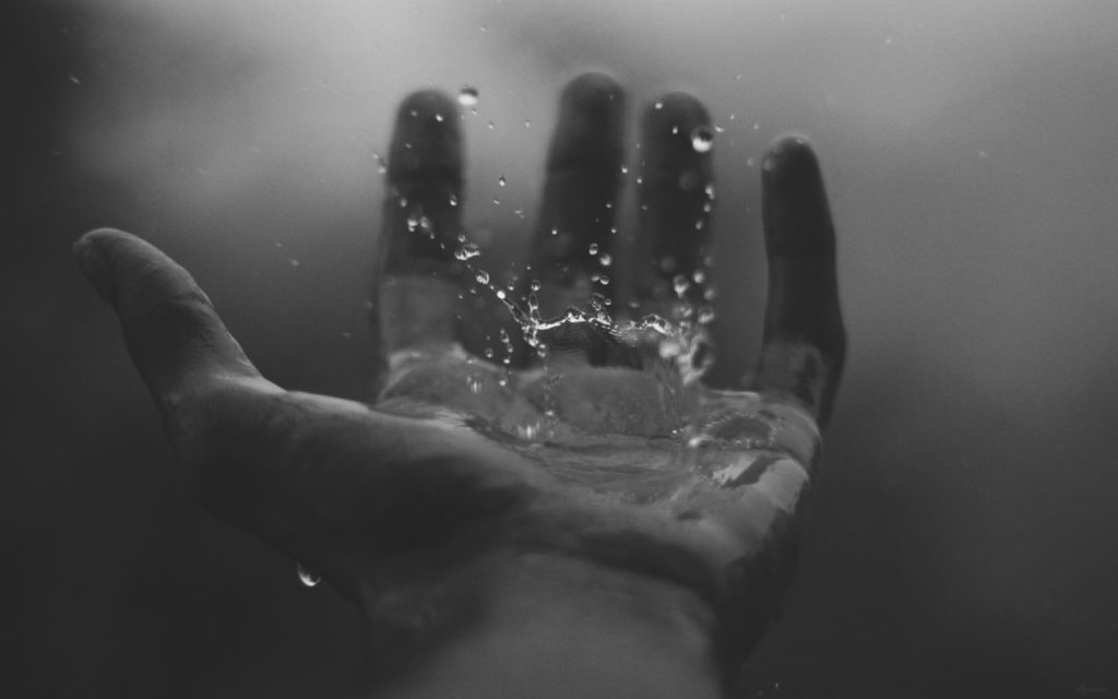 Hands being cleansed by water