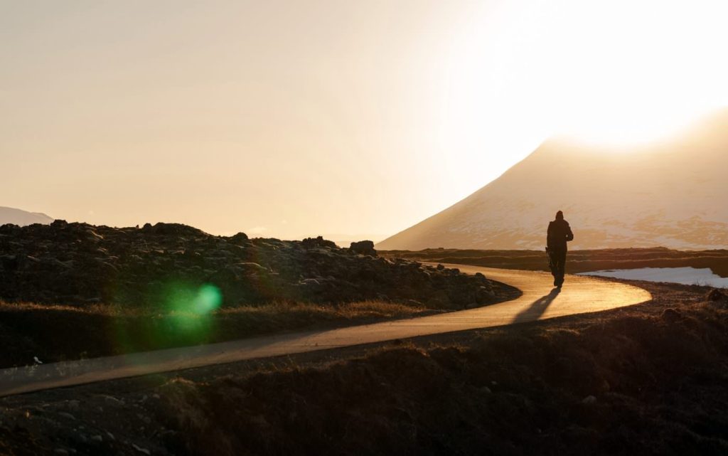Person walking along road into the horizon