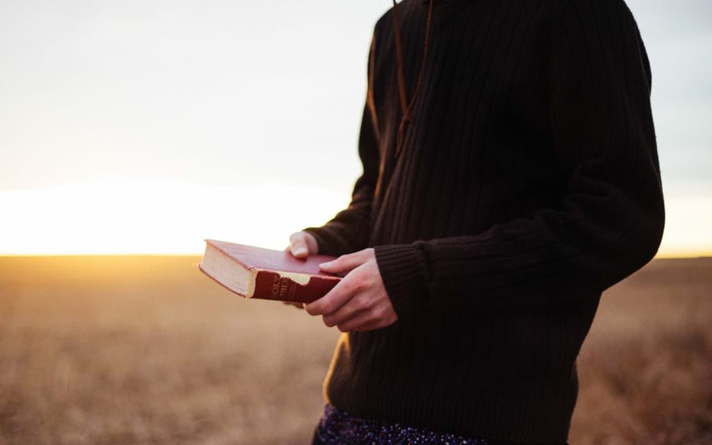 Person holding Bible in hands