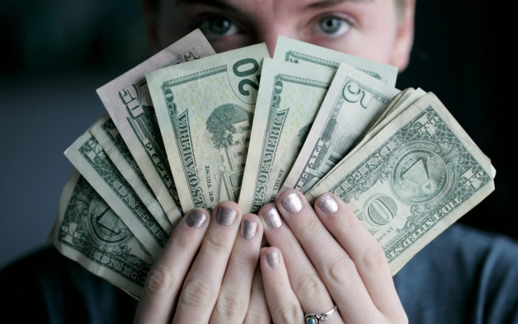 Woman holds money greedily